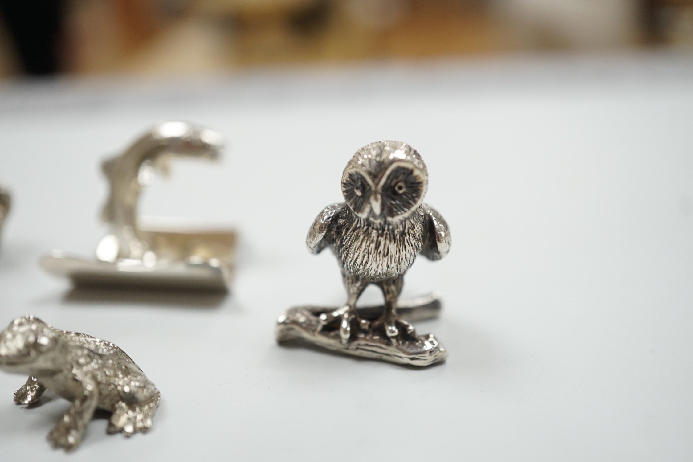 Eight assorted modern silver miniature animal or bird figures including menu holders, including rabbit by Tessiers Ltd, height 27mm, an earlier silver swan menu holder and a silver gilt owl brooch.